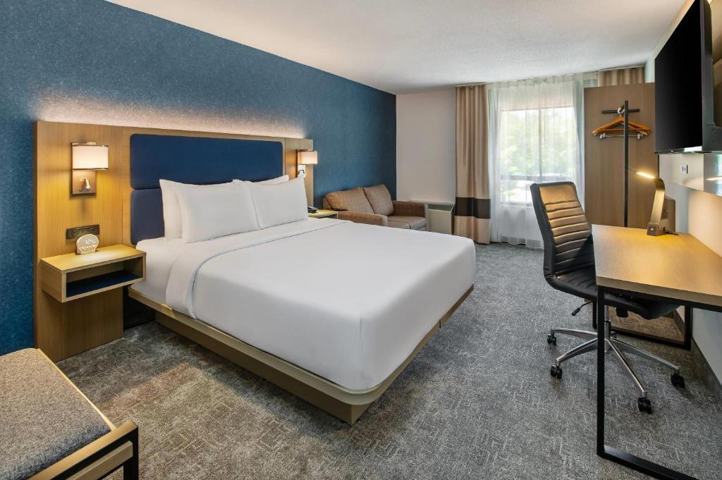 a hotel room with a large bed and a desk at Comfort Inn in North Bay