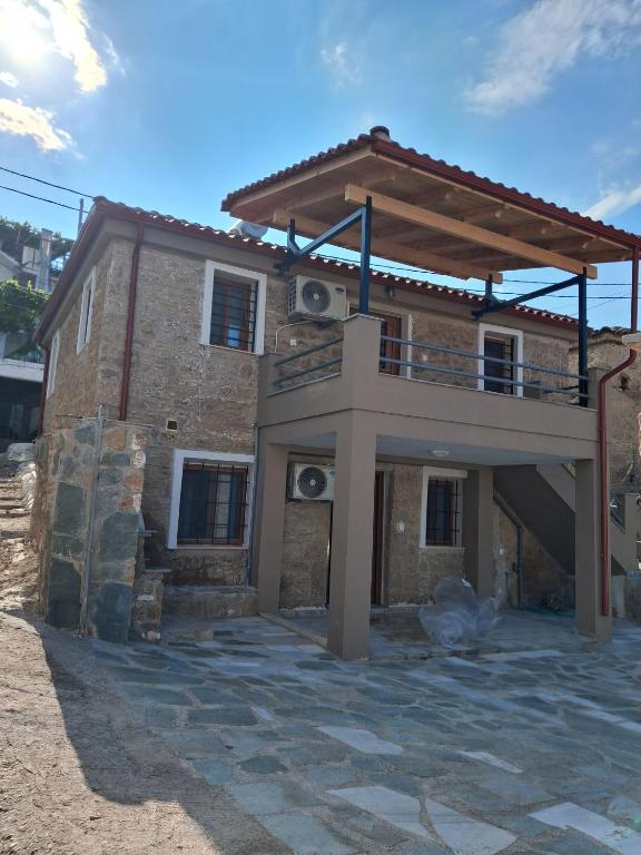 a house with a balcony on top of it at Makri Guest House in Livanates