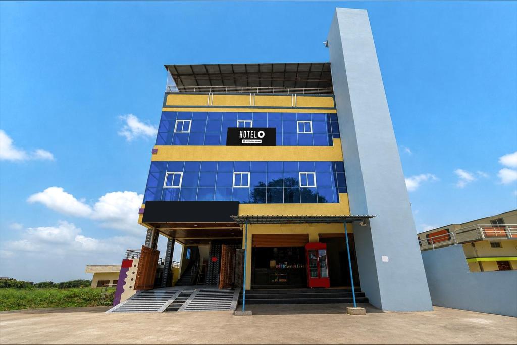 a blue and yellow building with a who sign on it at Hotel O Shadnagar Formerly Sri Jogulamba Residency in Bālānagar