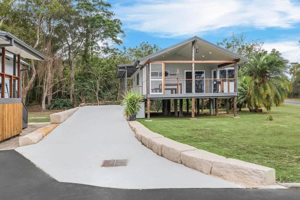a house with a driveway in front of it at The Palm Cabin 2 in Mylestom