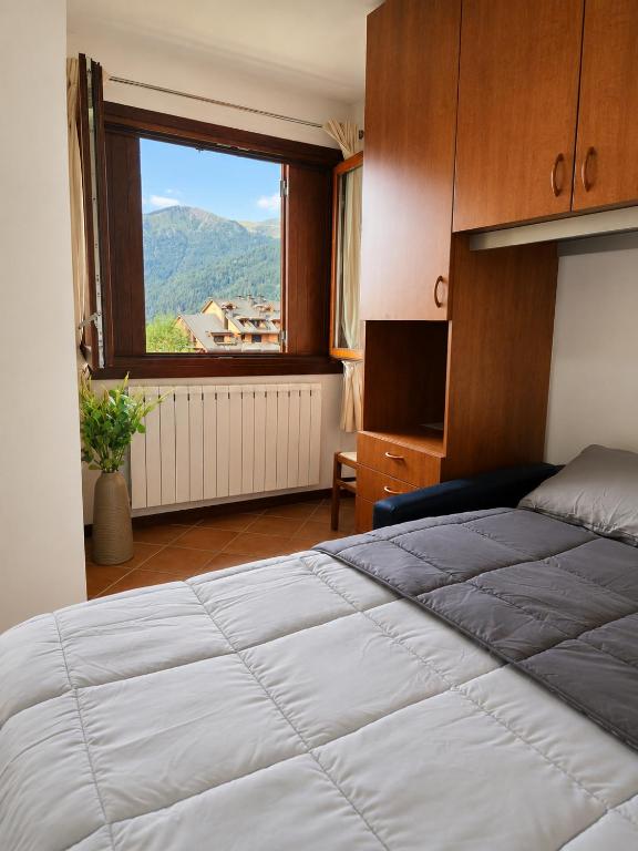 a bedroom with a large bed and a window at La Splaza Home in Pian Camuno