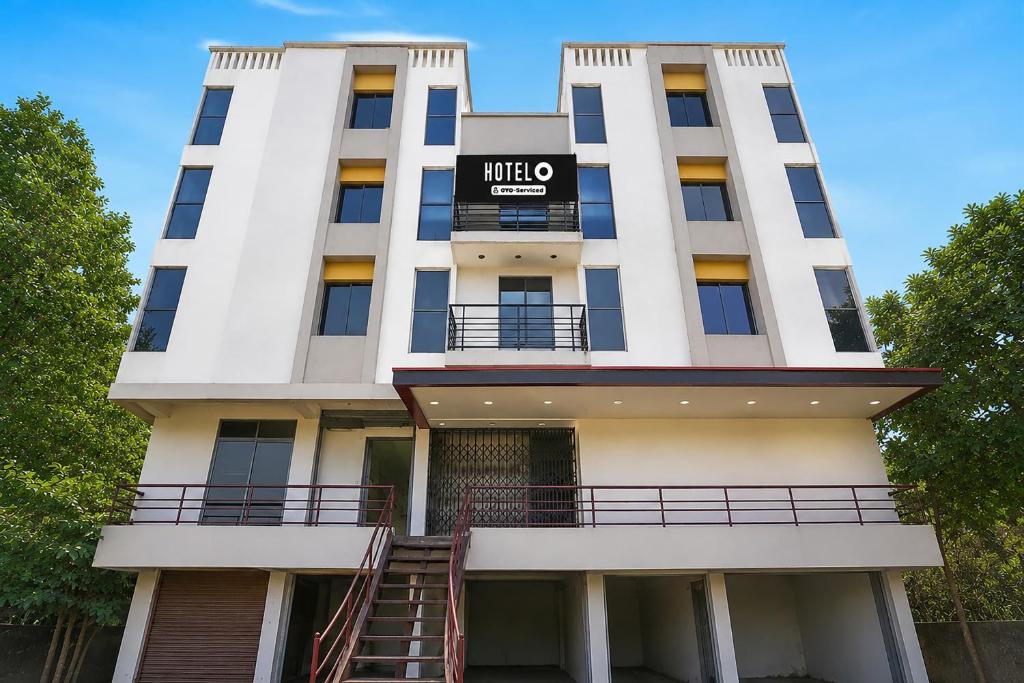 a tall white building with a hotel sign on it at Hotel O Sabarmati Ashram Ahmedabad Formerly Red Apple in Ahmedabad