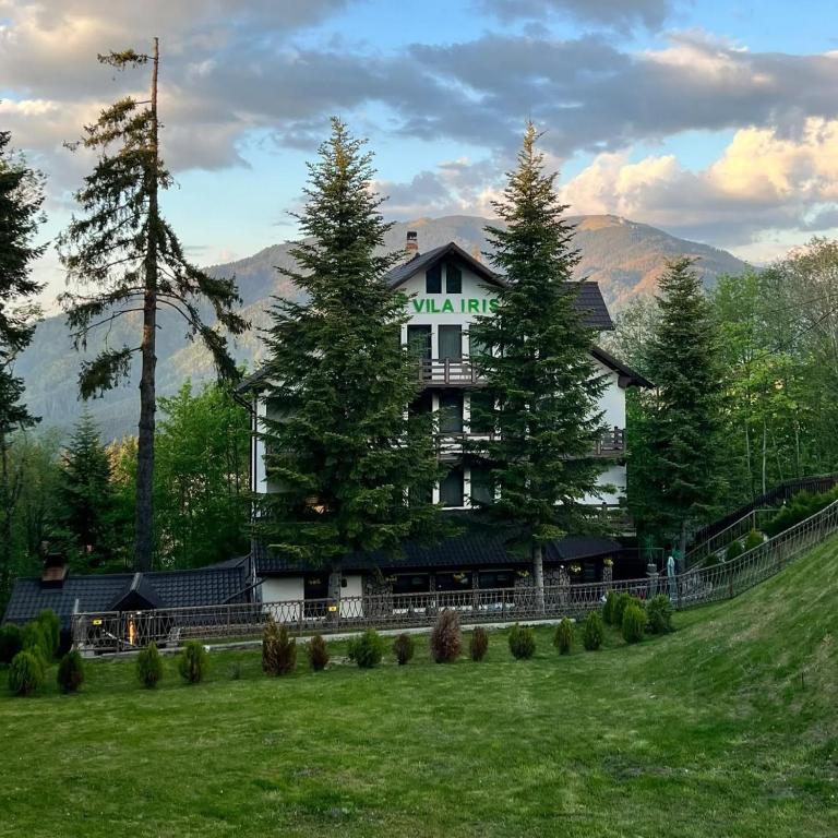 a large building with trees in front of a field at Iris Predeal in Predeal
