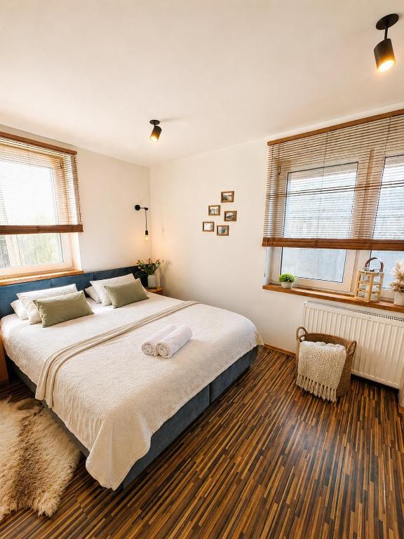 a bedroom with a large bed and two windows at Ku Słońcu -Pokoje&Apartamenty - Jastrzębia Góra in Jastrzębia Góra