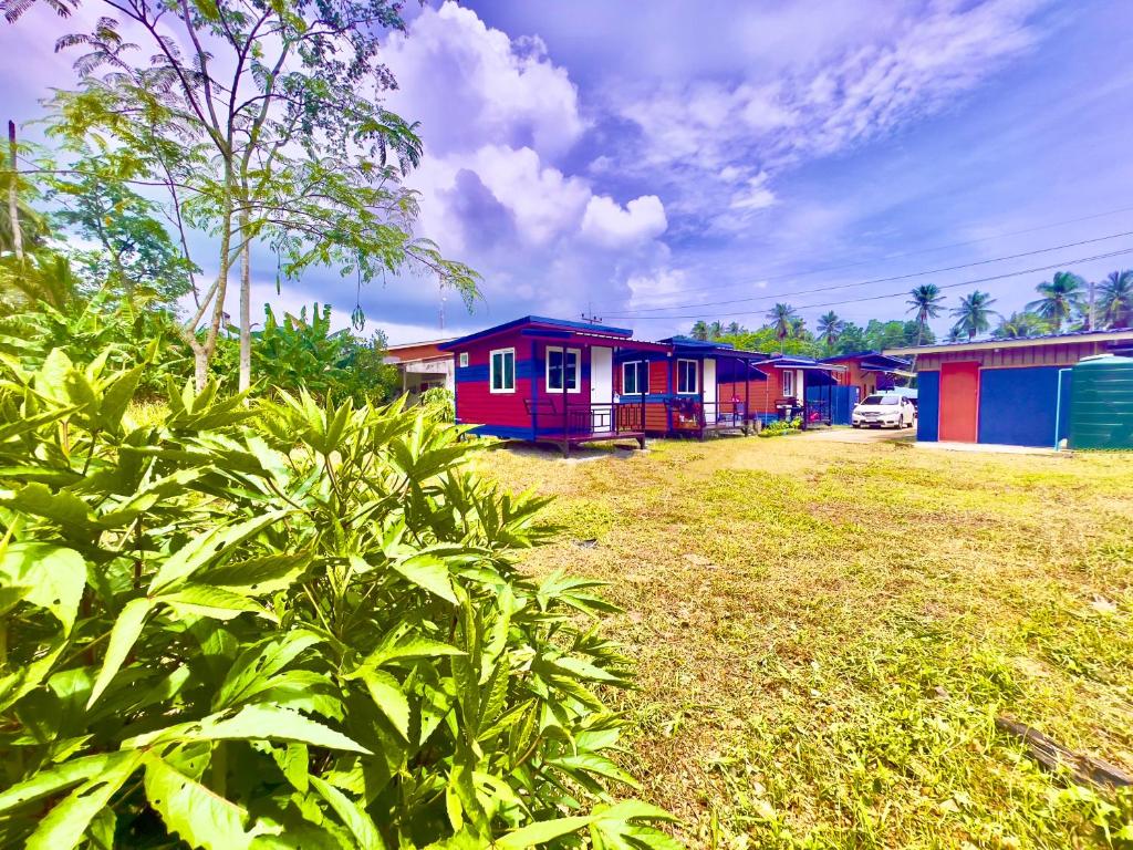 a row of colorful houses in a yard at Lamai Home Koh Yao Noi in Ko Yao Noi