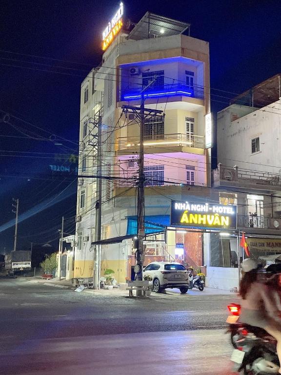 a building with a neon sign in front of it at ANH VAN Motel in Chau Doc