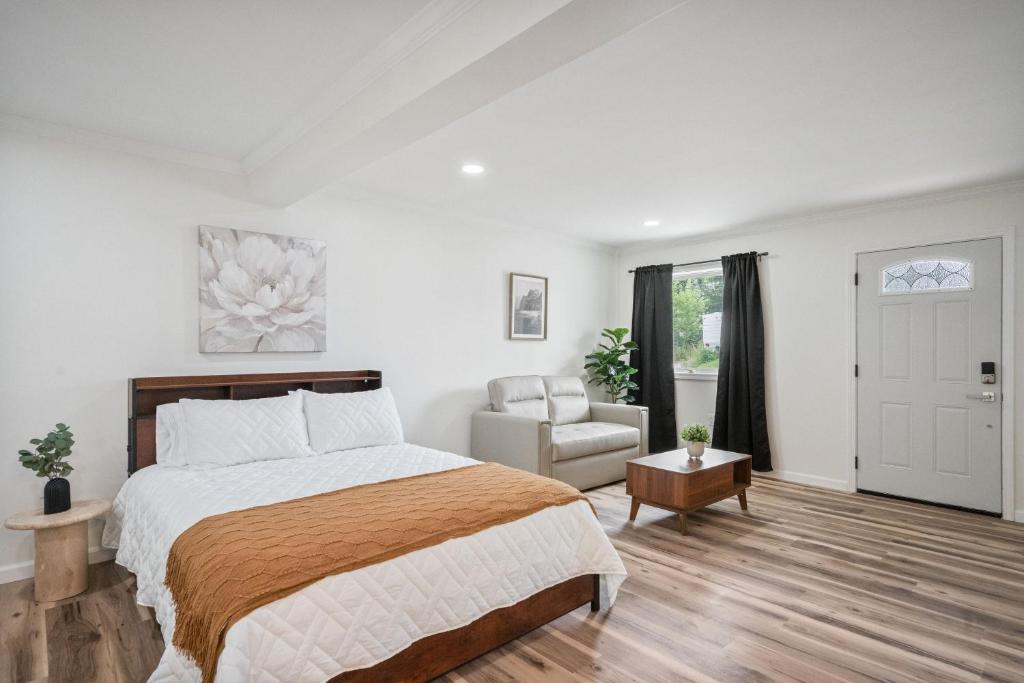 a white bedroom with a bed and a chair at Cashmere Private Studio Cozy Chic Escape in Kokomo