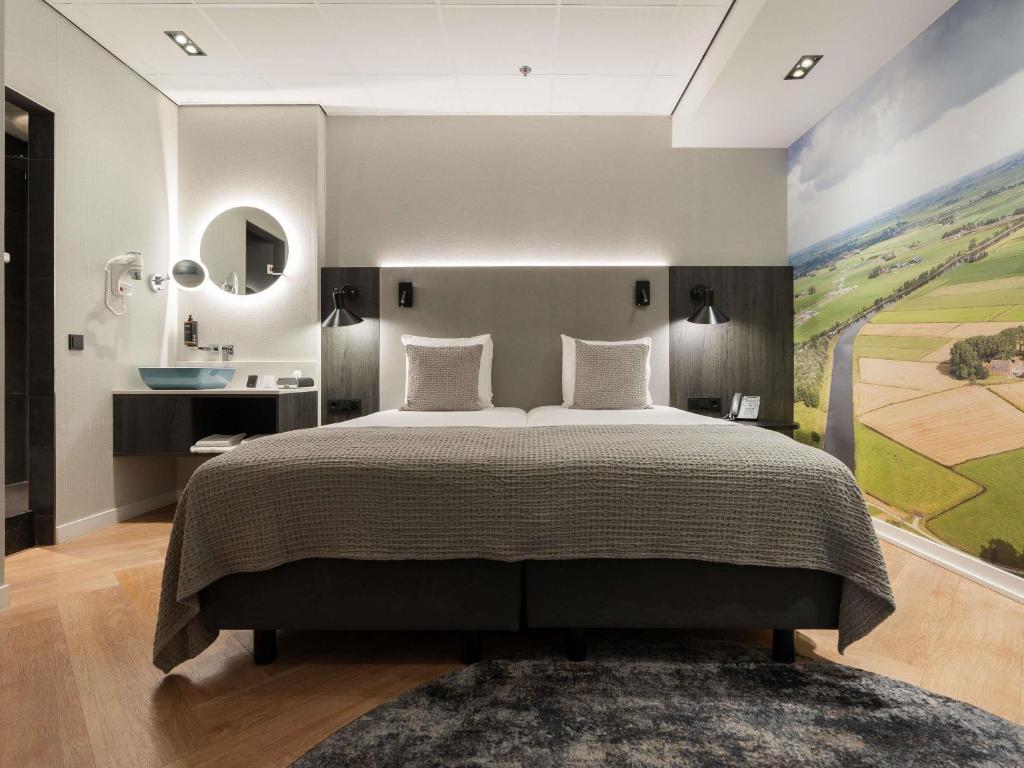 a bedroom with a bed and a painting on the wall at Mercure Hotel Schiphol Terminal in Schiphol