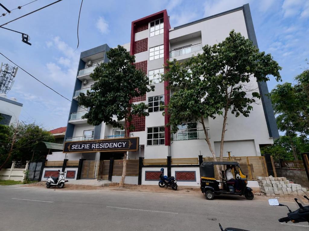 a building with a golf cart parked in front of it at Selfie Residency in Mysore