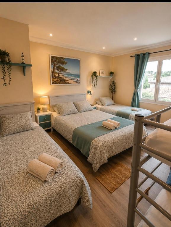 a bedroom with three beds and a staircase at Emporda Llanca Guesthouse in Llança