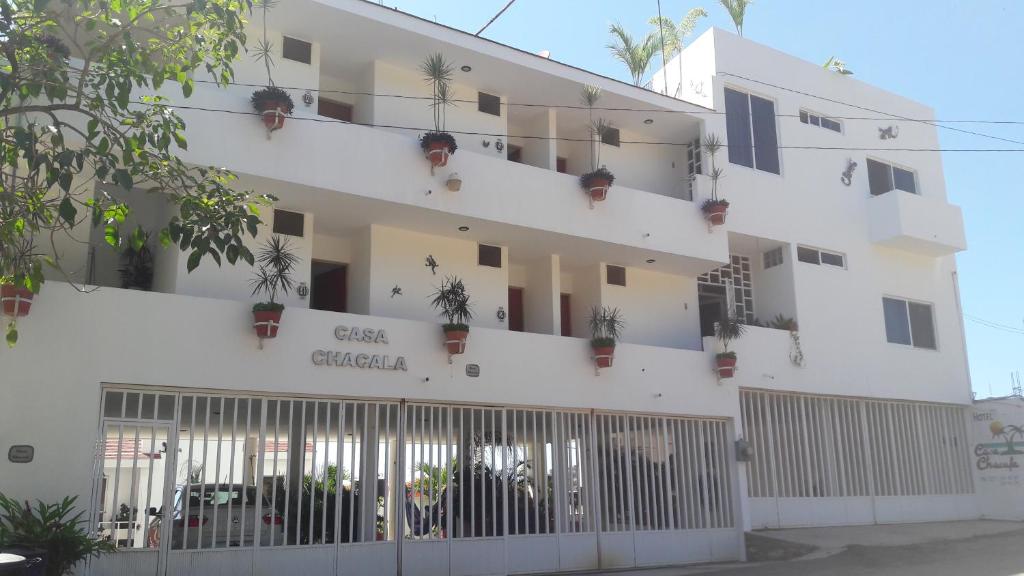 a white building with potted plants on it at Hotel Casa Chacala in Chacala