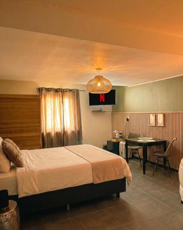 a bedroom with a bed and a dining room at Symbiose hotel in Charleroi