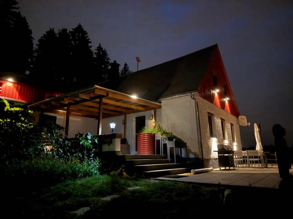 a house with a porch at night with lights at Familien Ferienhaus in Bad Elster Vogtland - Natur pur und Wellness in Bad Elster