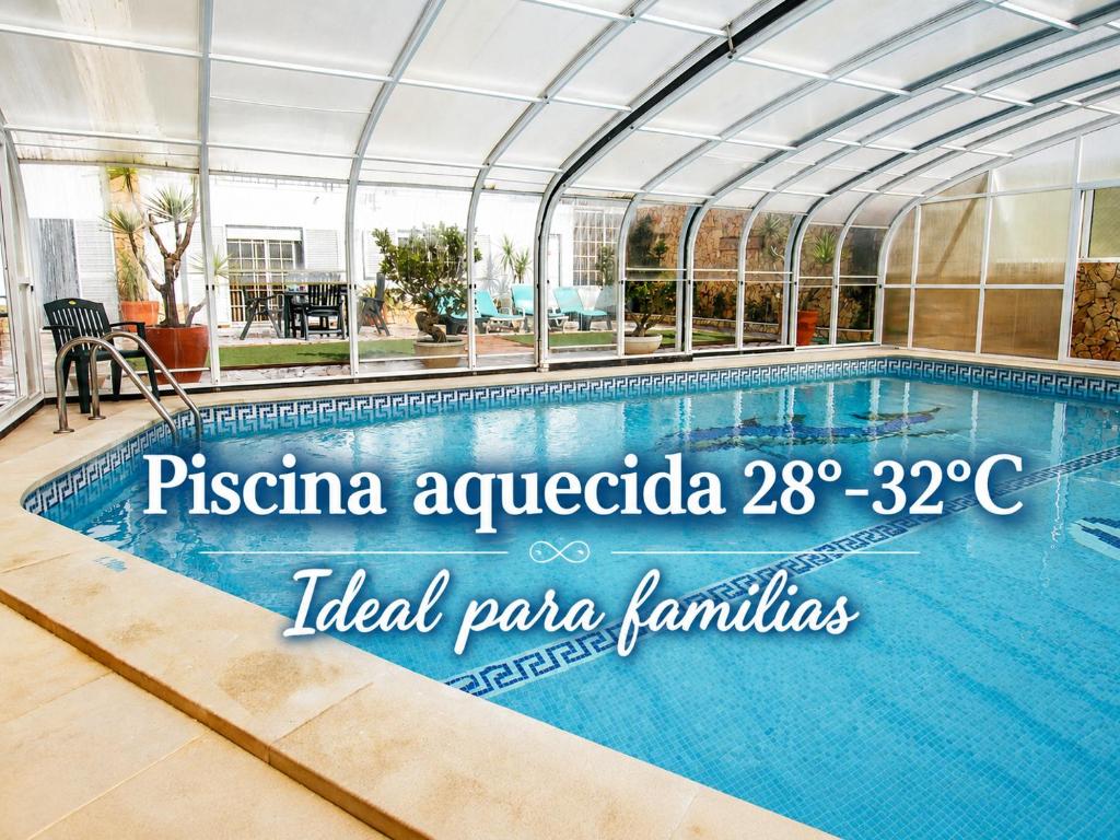 a swimming pool in a building with a glass ceiling at Dii Beach House - Piscina Aquecida 28º-32º C in Torres Vedras