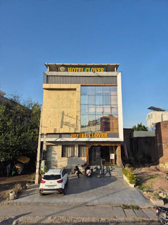 a hotel with a car parked in front of it at Hotel Clover in Zirakpur