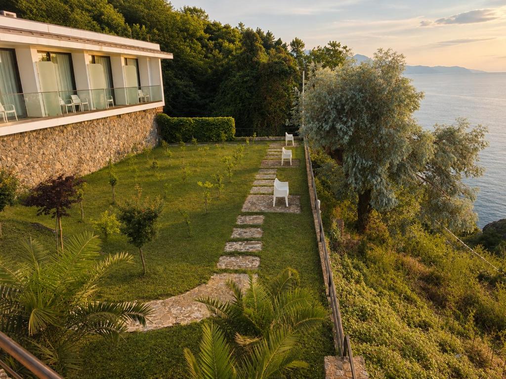 a garden with a bench on the side of a house at Mandrati Loft in Sarpi