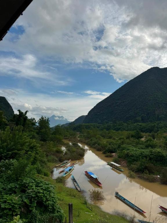 a river with boats in it with mountains in the background at Nam Ou Breeze in Ban Ngoy-Nua