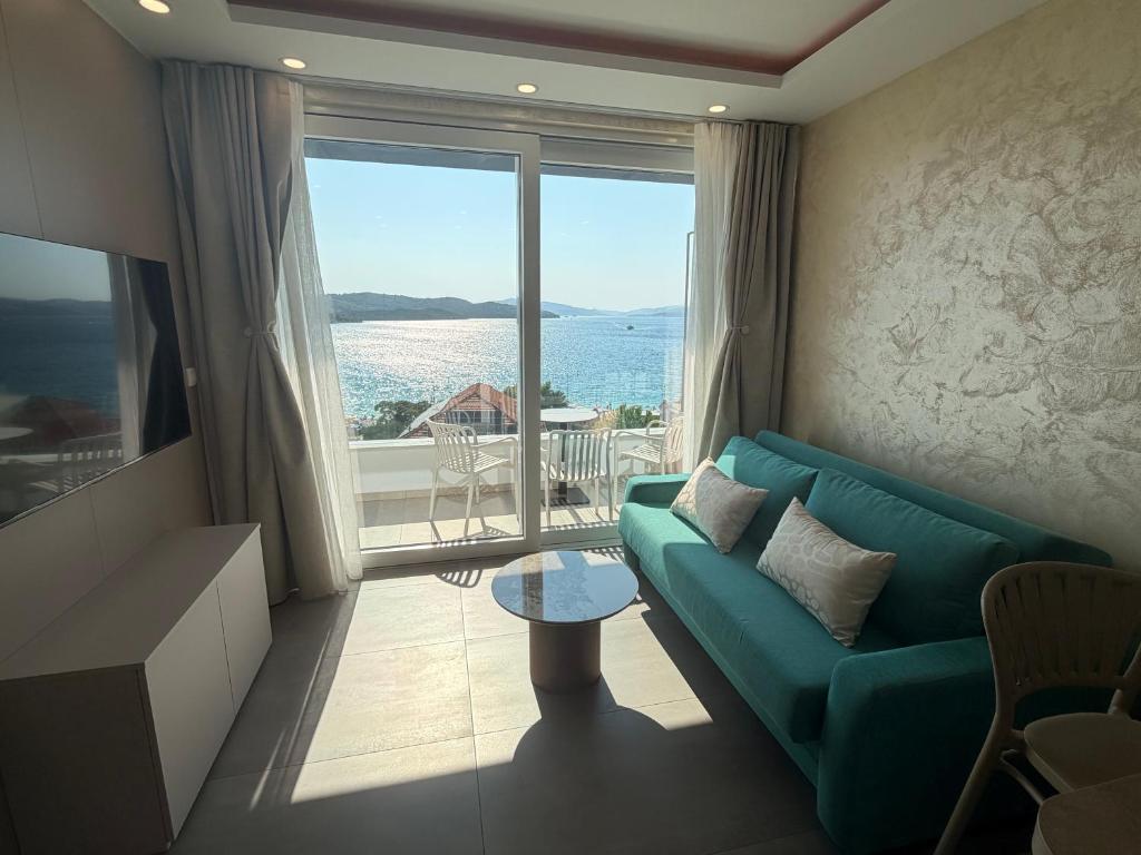a living room with a couch and a large window at Apartments Soho in Trogir
