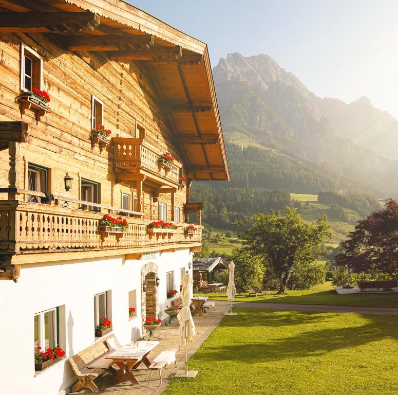 a building with a balcony and a table and chairs at Der Pfindlhof in Leogang