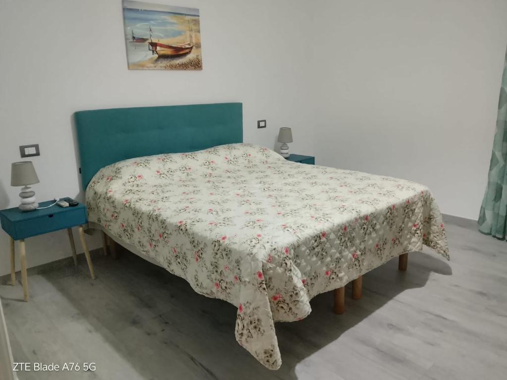 a bedroom with a bed with a floral bedspread on it at Casa Alba in Taranto