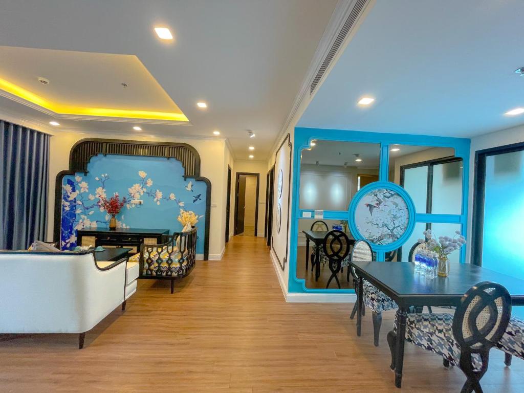 a living room with blue walls and a table and chairs at FLC Quy Nhơn Sea Condotel in Quy Nhon