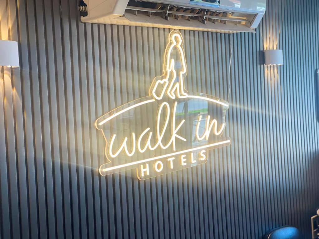 ein Neon-Schild mit der Aufschrift „Begehbare Hotels“ an einer Wand in der Unterkunft Walkin Hotel in Konak