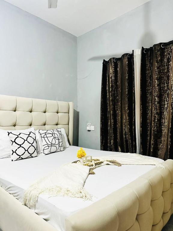 a bedroom with a large white bed with black curtains at The Mason Hideout in Watamu