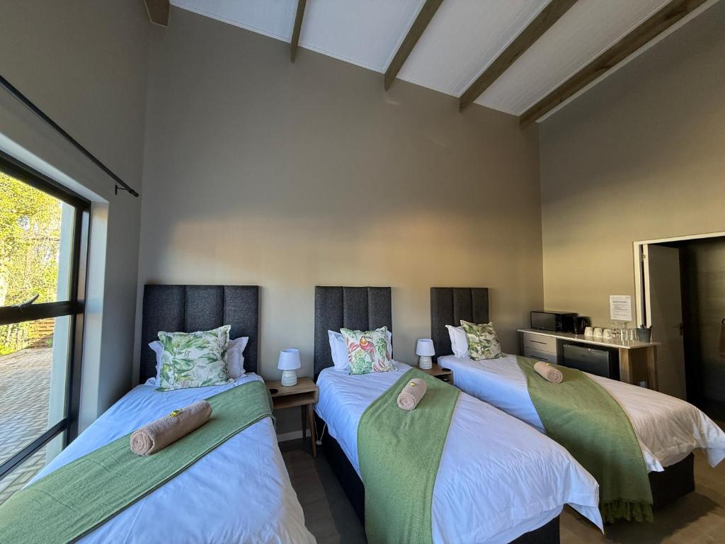 two beds in a room with a window at Autumn's Rest in George