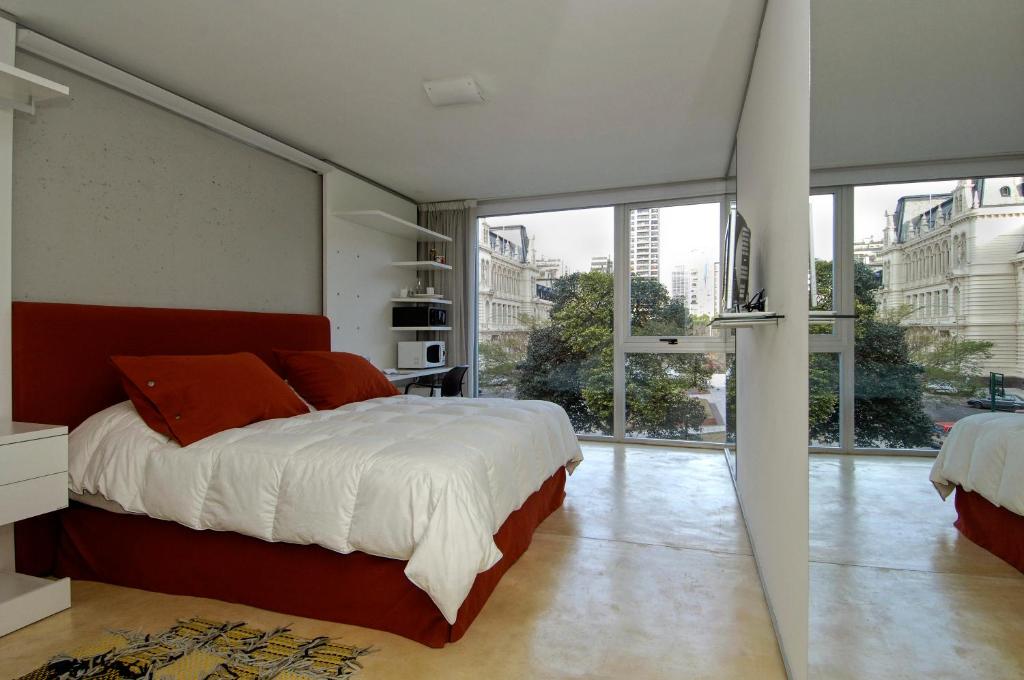 Design cE - Hotel Boutique de Diseño في بوينس آيرس: غرفة نوم بسرير كبير ونافذة كبيرة