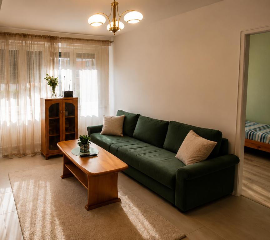 a living room with a green couch and a coffee table at Apartament Okrzei in Lublin