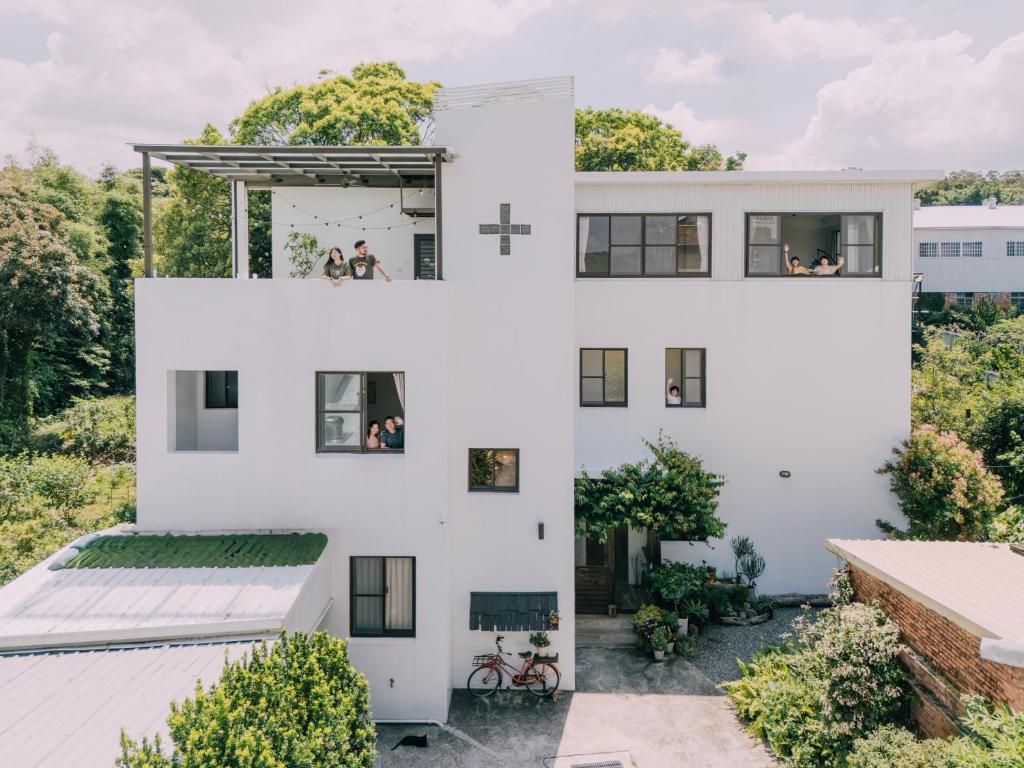 a white house with a cross on the side of it at Tree House Café & Homestay in Tongluo