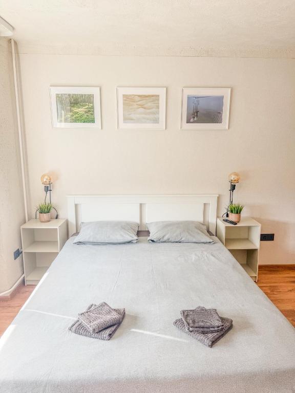 ein Schlafzimmer mit einem weißen Bett, auf dem zwei Handtücher liegen in der Unterkunft Kalmāri in Kolka