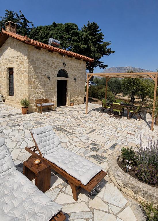 a stone patio with two couches and a table at Olive Stonehouse Sea and Mountain View in Áyios Míron