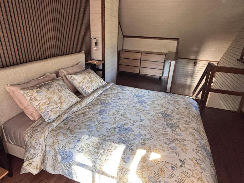 a bedroom with a bed with a blue and white comforter at Võsula Tornimaja apartments in Võsu