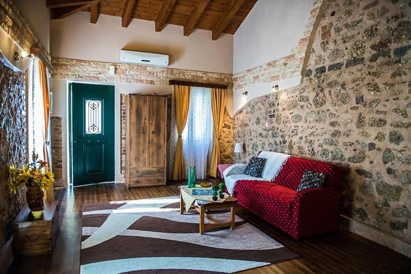 uma sala de estar com um sofá vermelho e uma mesa em Jason's Stone House em Ágios Matthaíos