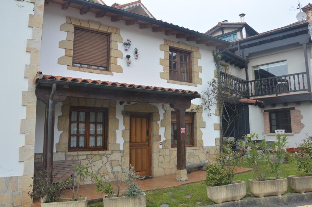 a house with wooden doors and windows at La casuca in Noja