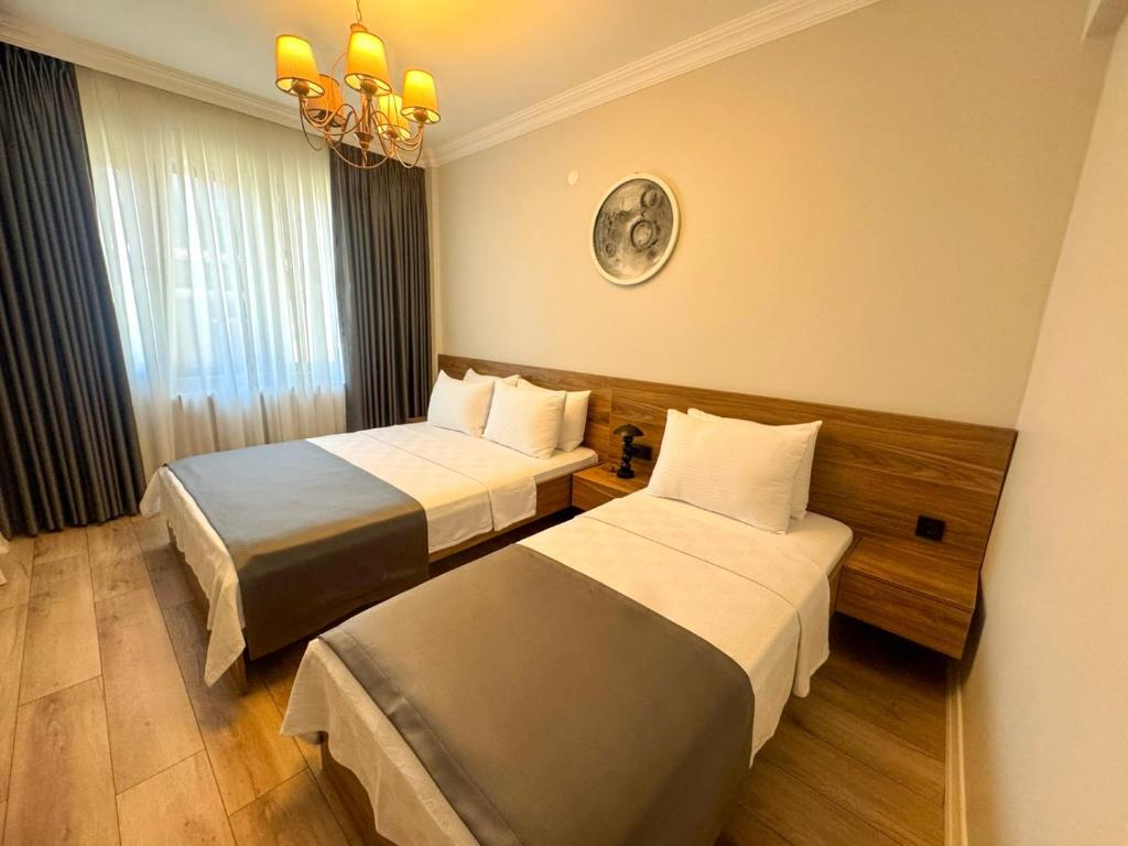 a hotel room with two beds and a chandelier at Fethibey Otel in Bartın