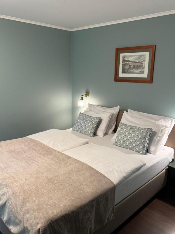 a large bed with white sheets and pillows at Decor Park Apartament in Karpacz