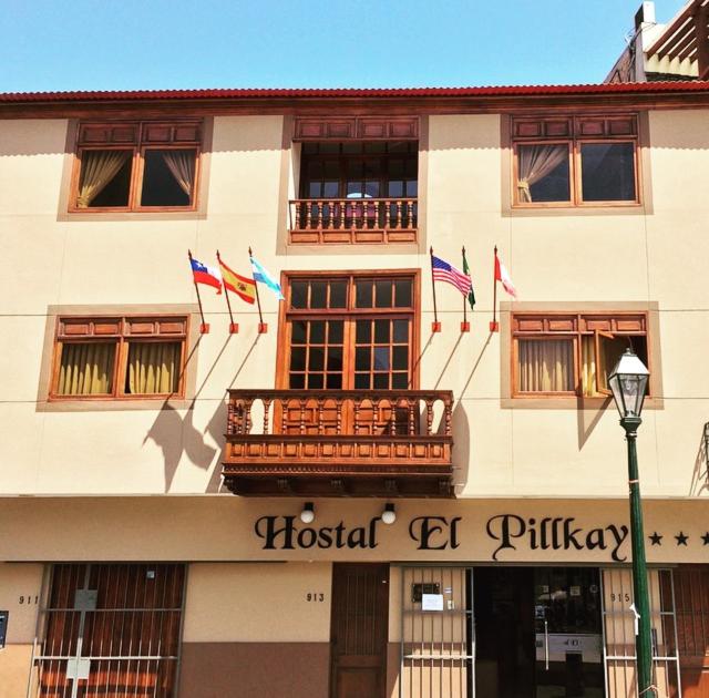 un edificio con banderas a un lado. en Hostal El Pillkay, en Trujillo