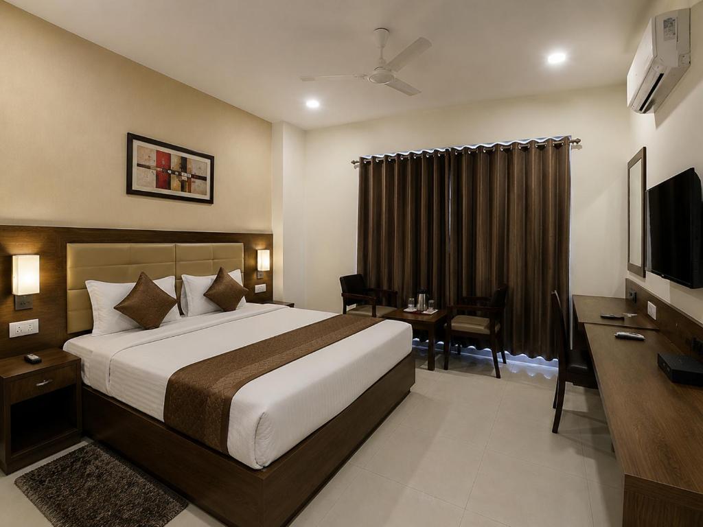 a bedroom with a bed and a desk and a television at Hotel S-mart In Delhi Airport & Free Airport Pickup in New Delhi