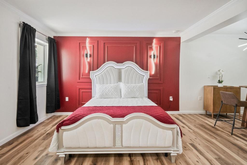 a white bed in a room with red walls at Clair de Lune Studio A Charming Kokomo Stay in Kokomo
