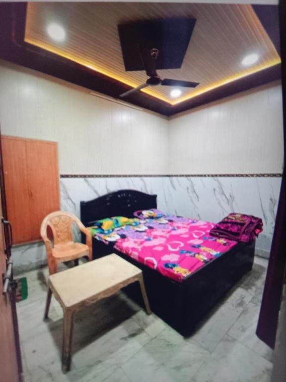 a room with a bed and a table and a chair at Paras guest house in Mathura