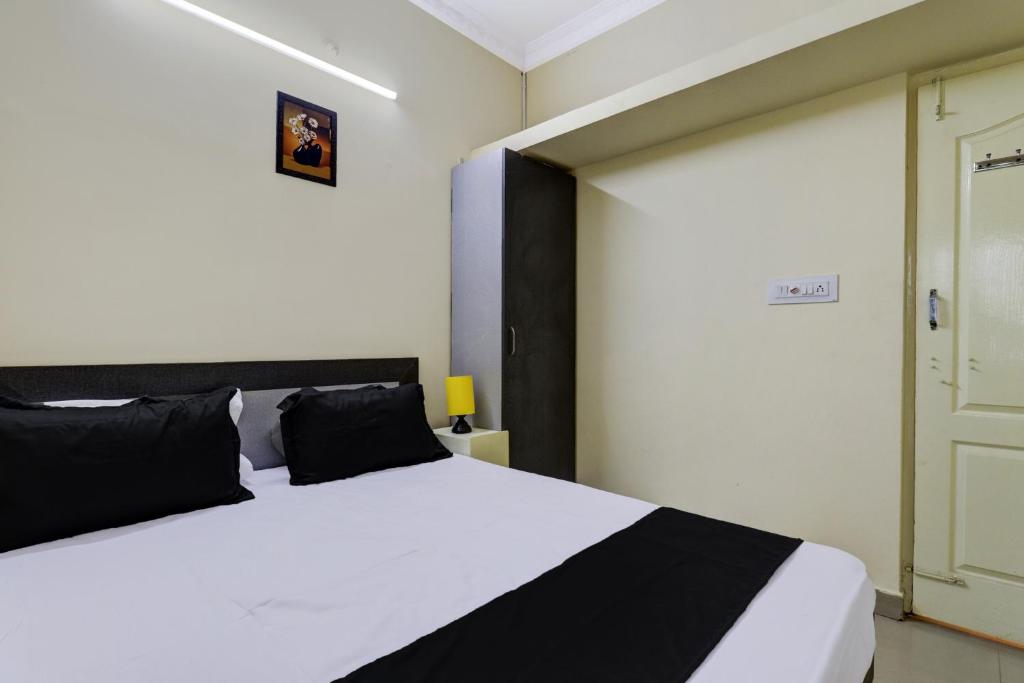 a bedroom with a large white bed and a door at Hotel O Indian Residency, Near Adams Academy, Kadugodi in Bangalore