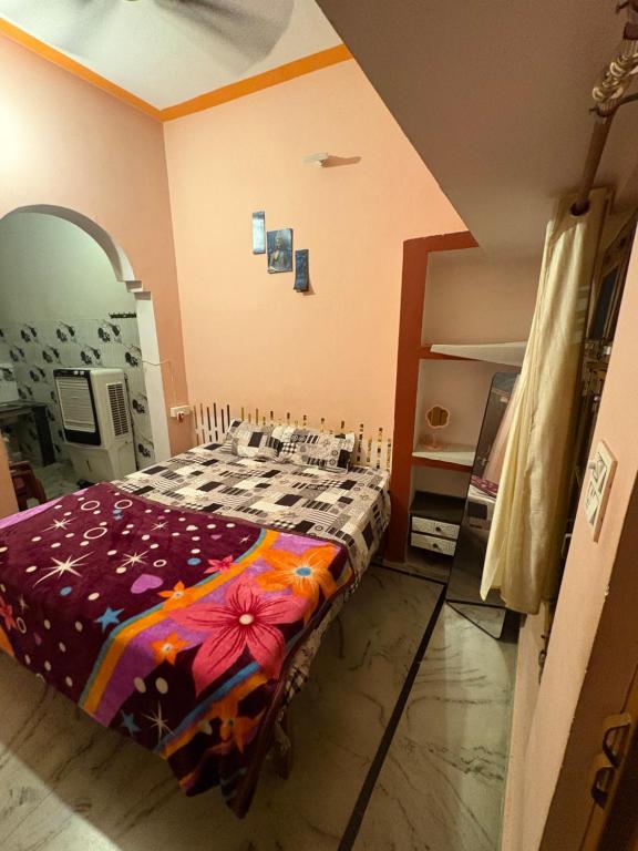 a bedroom with a bed with a flower blanket at Arav Homestay in Rishīkesh