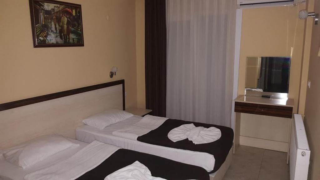 ein Hotelzimmer mit 2 Betten und einem TV in der Unterkunft Blue Sea Hotel & Spa in Kusadası