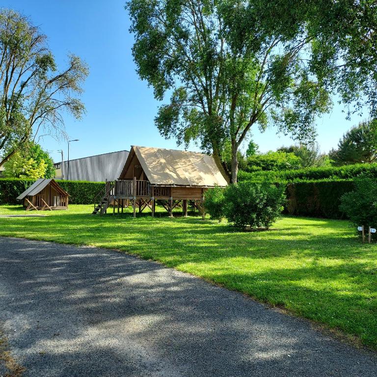 a barn sitting in the grass next to a road at Camping Port la Vallée in Saint-Mathurin
