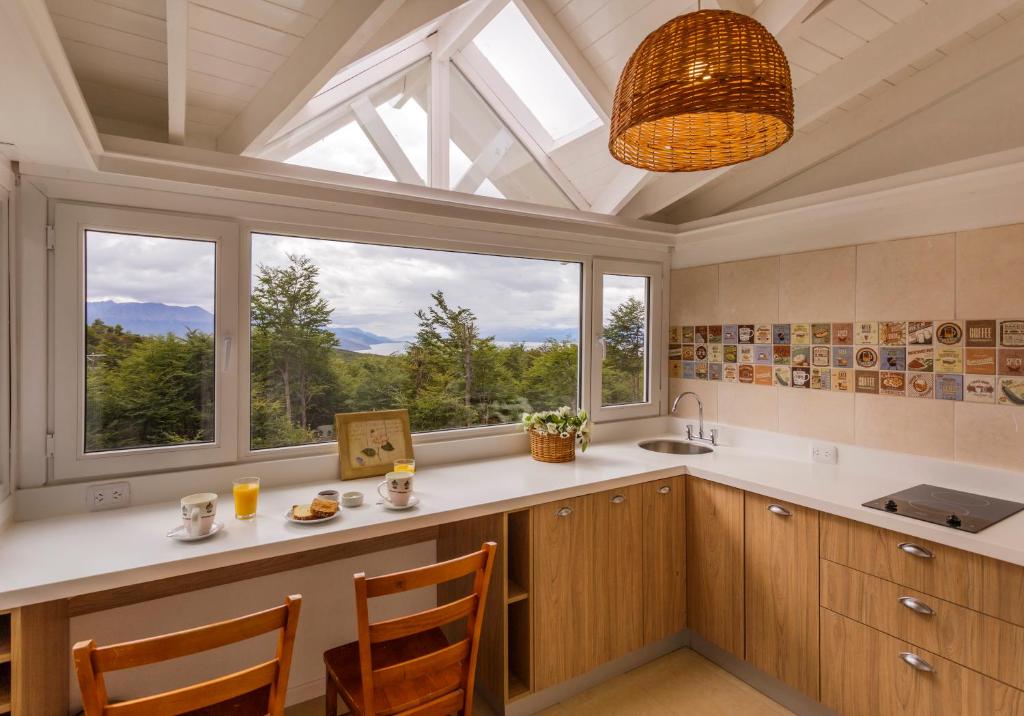 uma cozinha com uma grande janela e uma mesa com cadeiras em Cumbres Del Martial em Ushuaia