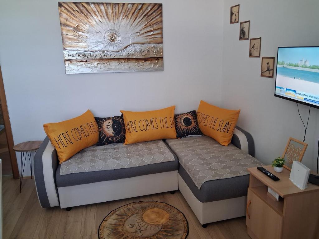 a living room with a couch and a tv at Sunshine- self sheck in in Čačak