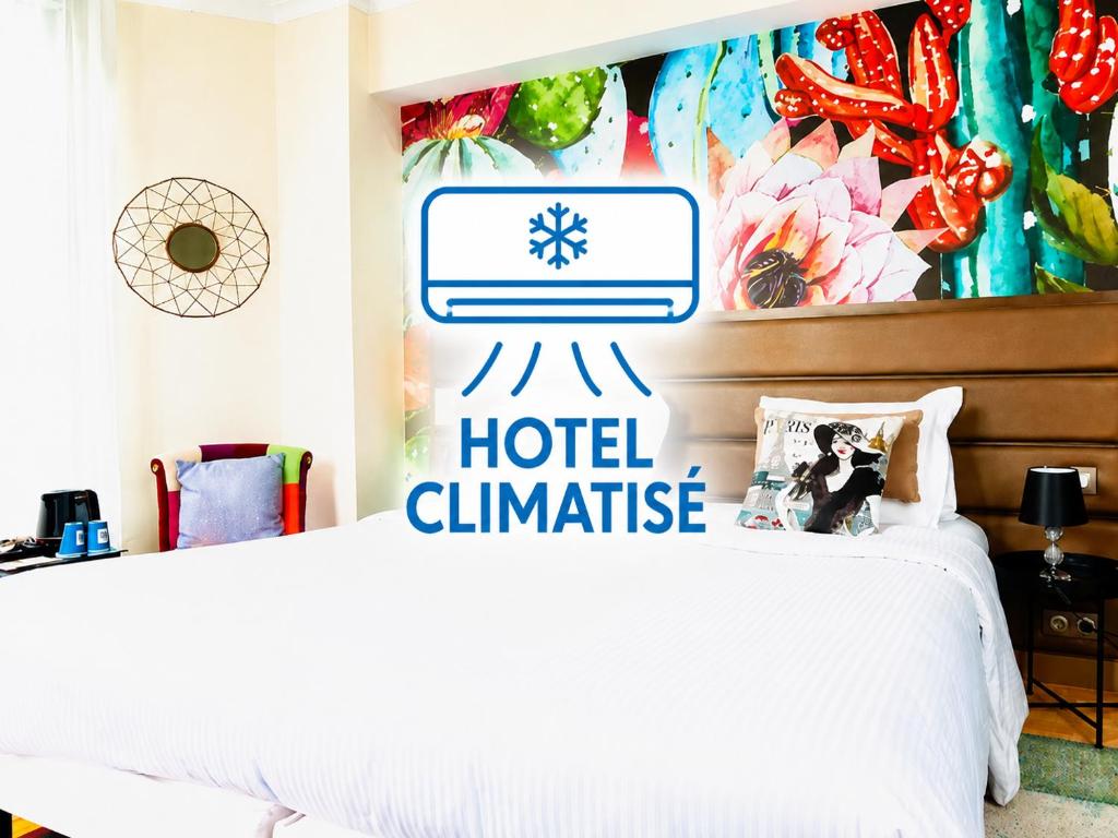 a bedroom with a hotel challenge sign on the wall at Kyriad Restaurant Centre SPA Vichy in Vichy