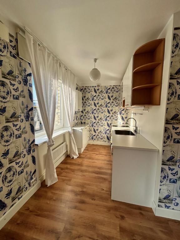 a kitchen with blue and white wallpaper and a sink at Ottenson Saaremaa apartment in Salme
